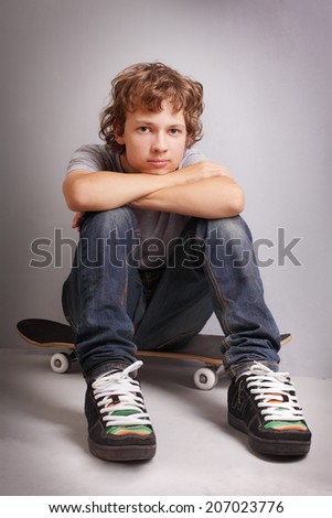 happy boy sitting on skateboard