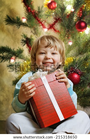 happy boy with christmas gift near Christmas tree