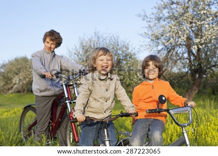 three brothers ride bikes outdoors
