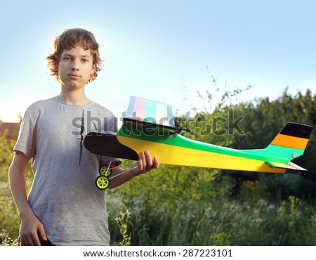 Teen with homemade radio-controlled model aircraft (airplane is hand made not copyright)