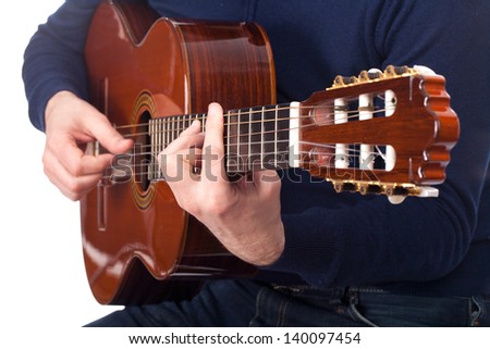 Brown guitar in hands of the guy playing it