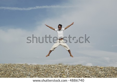 young man jumps of arms and open legs, to the outdoors...