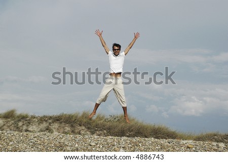 young man jumps of joy of arms and open legs... to the outdoors...