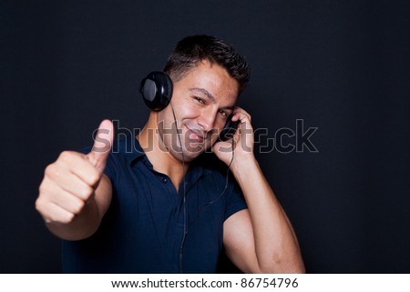 young man with headphones on his ears and making ok sign