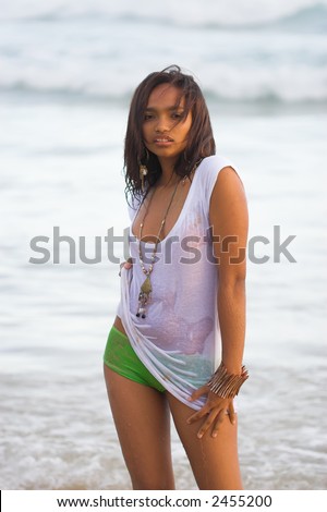 Ethnic girl in wet t-shirt at the beach