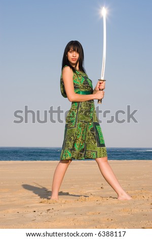 Ethnic Model posing with a sword at the beach
