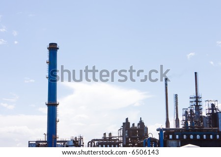 Factory with smoke stacks against blue sky