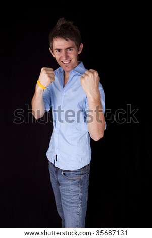 Young man with fighting stance on black