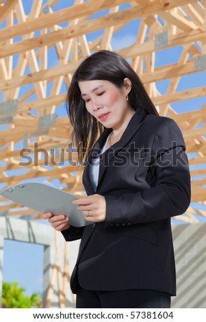 Asian Woman Contractor looking at job sheet
