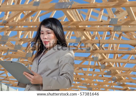 Asian Woman Contractor looking at job sheet on location