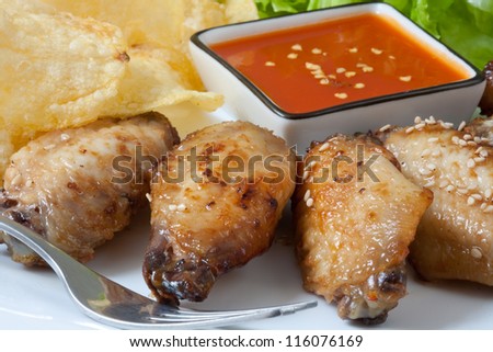 Grilled chicken wings with hot pepper sauce and chips