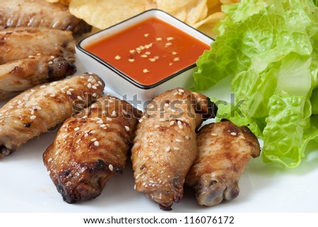 Grilled chicken wings with hot pepper sauce and chips