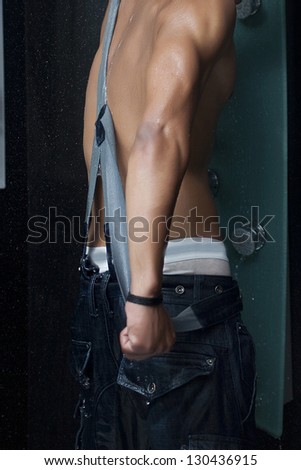 Back of sexy muscular man under a shower with drops of water