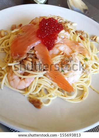 spaghetti with salmon and prawn on caviar sauce
