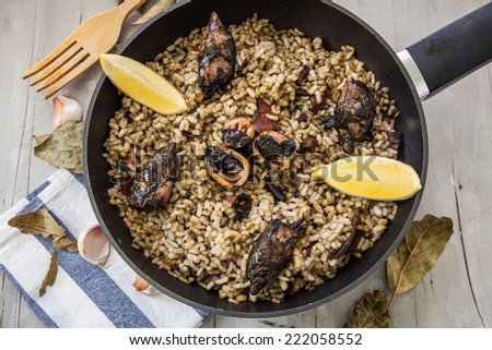 rice with squid on ink sauce on pan