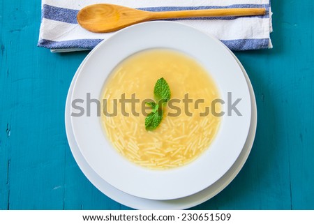 chicken soup served on white dish white spoon