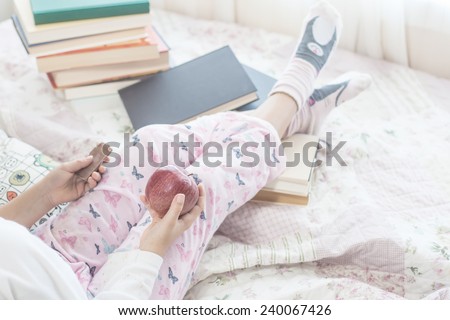 a girl reading a book while eat an apple. Vintage process