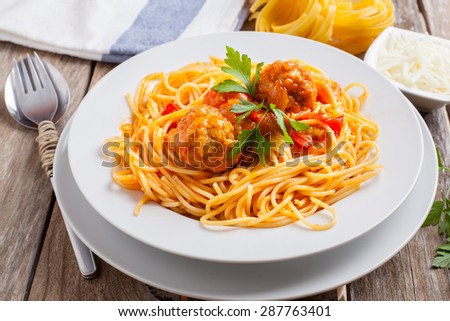pasta with meatballs and parsley with tomato sauce on white plate