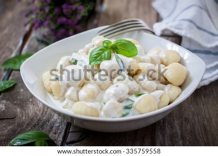 potato gnocchi pasta with cheese sauce and basil