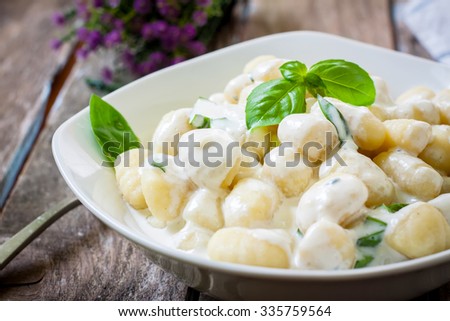 potato gnocchi pasta with cheese sauce and basil