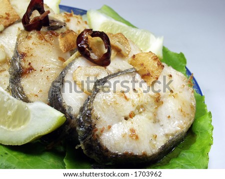 Slices of fried hake whit garlic and lemon