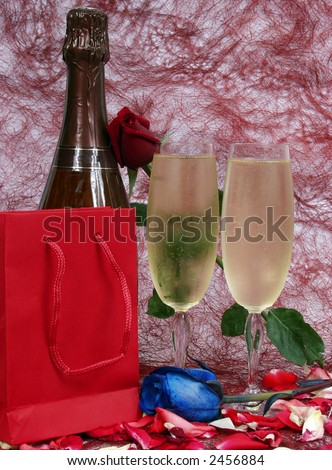 champagne bottle and two cups for celebrate san valentine`s day with red bag for presents