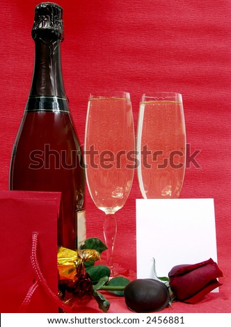 champagne bottle and two cups for celebrate san valentine`s day with a blank card
