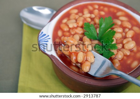 tasty tomato sauce beans on brown bowl with spoon