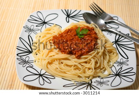 Plate of spaghetti with tomato bolognese sauce and a fork.