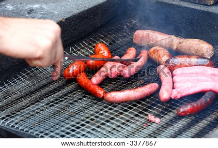 cooking white and red sausage on outdoor barbecue
