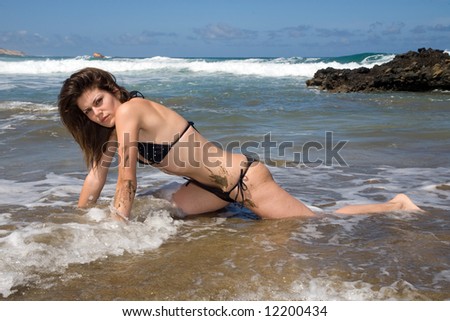 sexy young woman with black bikini in the beach under blue sky