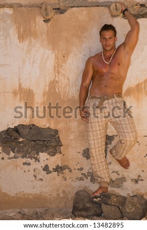 young athletic man posing in old house
