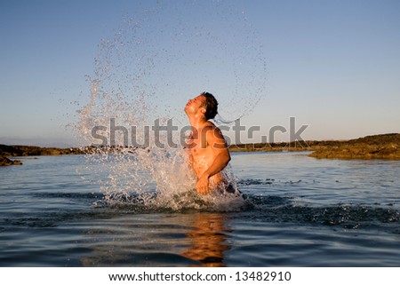 young athletic man jumping in the sea water