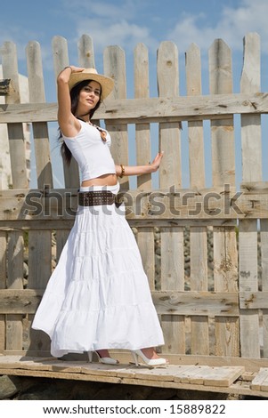 young attractive woman posing on old wood fence