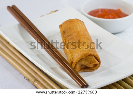 fried egg roll with chopstick and hot sauce