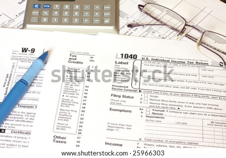 filling federal tax forms with a blue pen