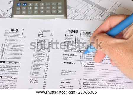 a single man filling federal tax forms with a pen