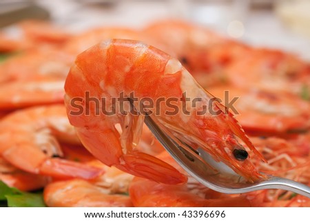 delicious boiled prawn on fork with food background