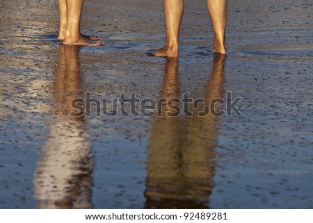two human legs walking in the beach