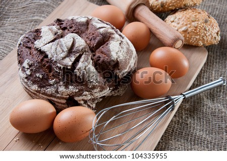 Making bread: whole grain wheat bread, brown eggs and kitchen utensils