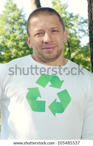 Green strongman standing by the tree in a summer park