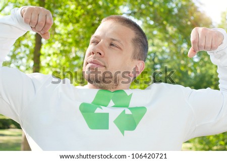 Environmental protection concept: green strongman flexing his recycling muscles outdoors