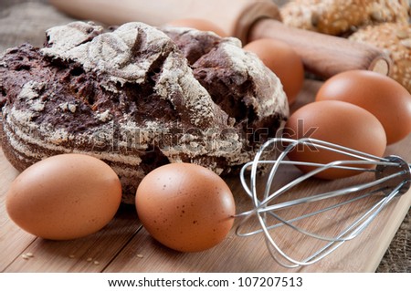 Making bread: loaf of fresh bread, eggs and kitchen utensils