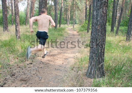 An adult caucasian male jogging outdoors, blurred motion, focus on the gravel path