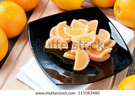 Glass plate with orange marmalade and fresh organic oranges