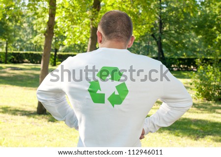Strongman in a shirt with green recycling symbol flexing muscles