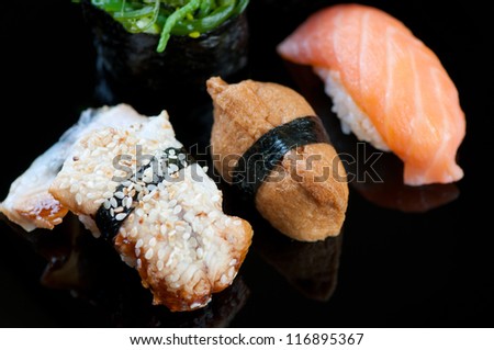 Black plate with variety of sushi, studio shot