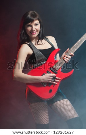 Smiling caucasian woman playing the guitar, vertical shot