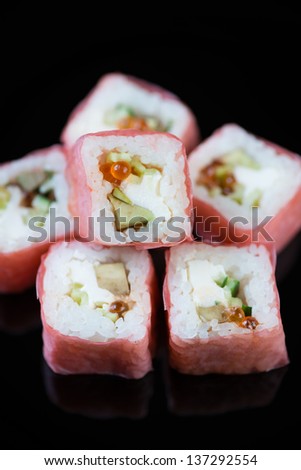 Close-up of pink panther rolls on a black plate, vertical shot