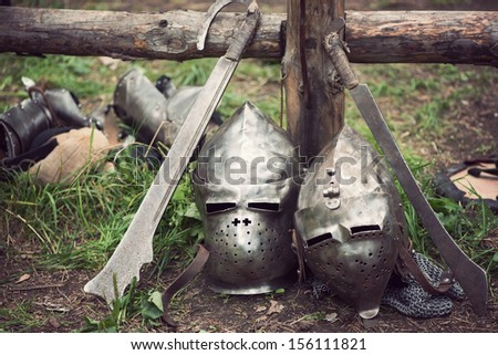 Two medieval helmets and swords, horizontal shot